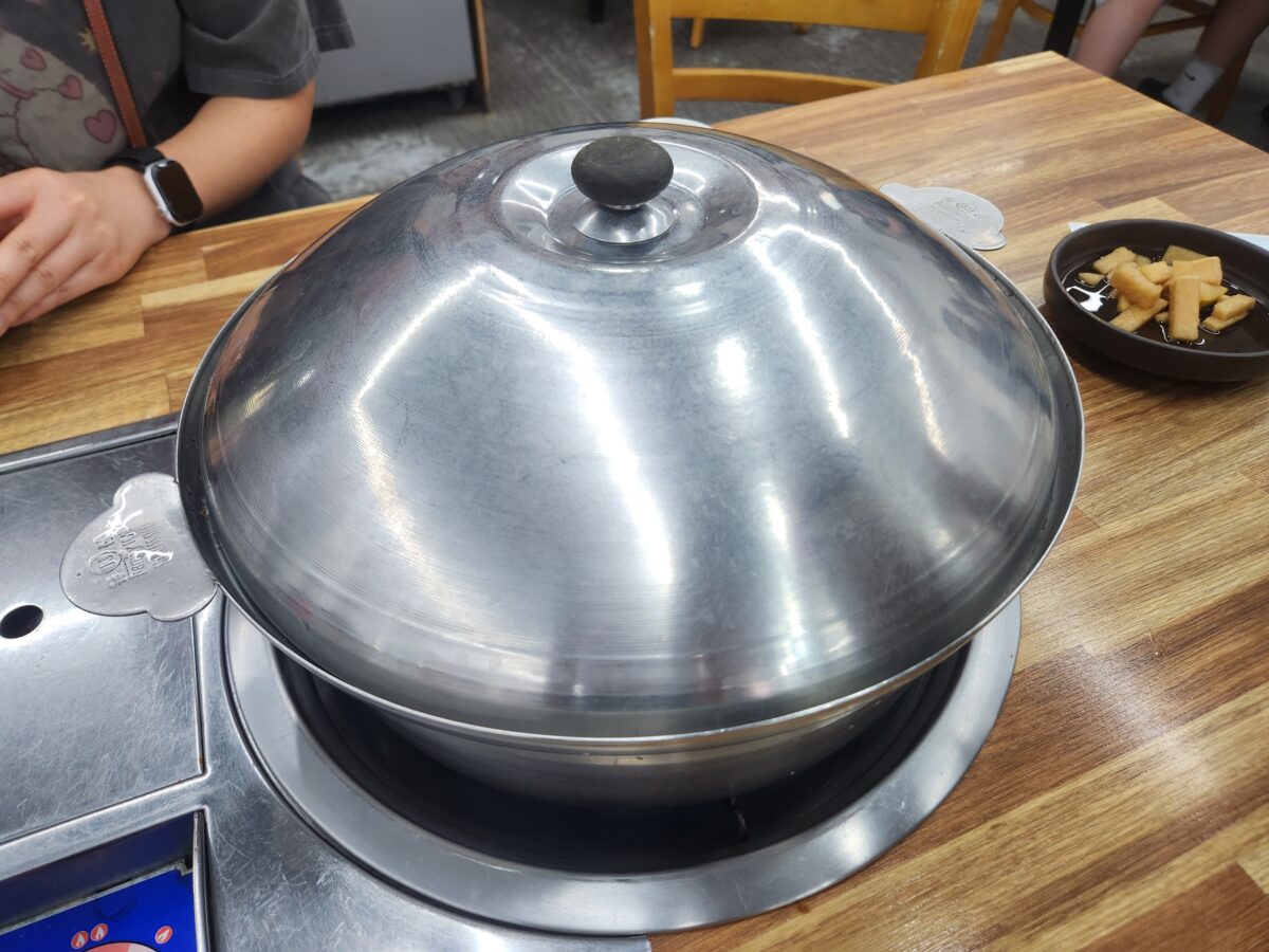 테이블 위에 놓인 뚜껑 덮인 칼국수 냄비