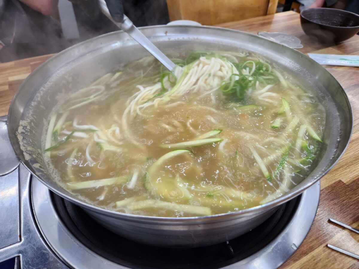 칼국수 냄비에 면을 넣고 젓는 모습