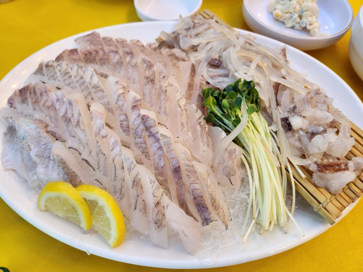 상 위에 차려진 우럭회와 오징어회 접시 근접 샷.