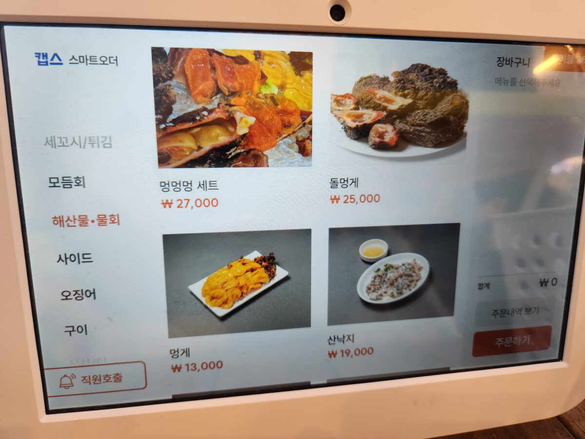 매장 내 주문용 키오스크 화면에 보이는 멍멍멍 세트, 돌멍게 등 해산물 메뉴들.
