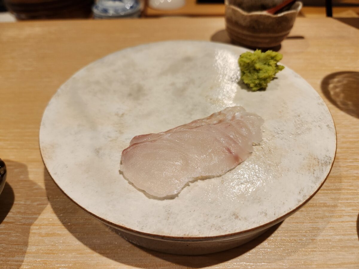접시 위에 놓인 광어회 한 점.
