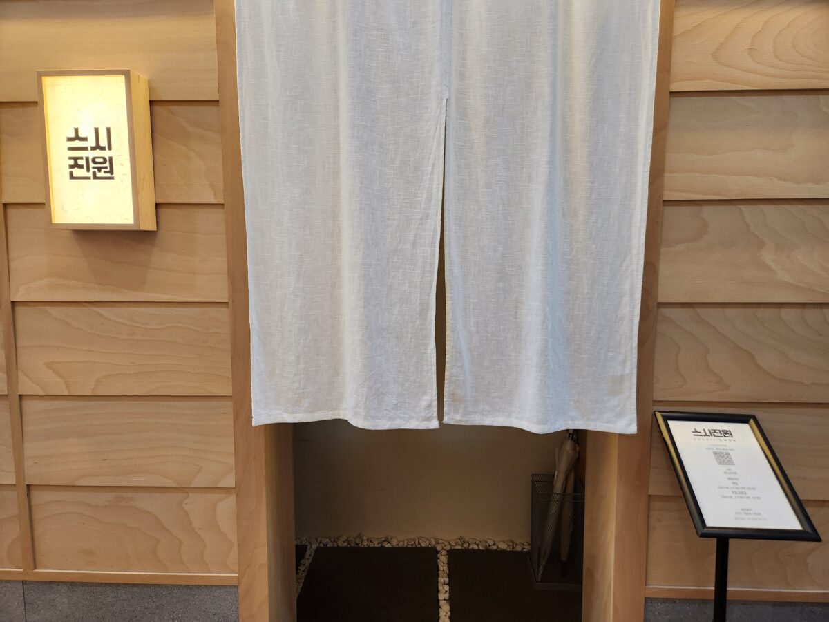 스시진원 상호가 적힌 입구 간판과 흰색 노렌.