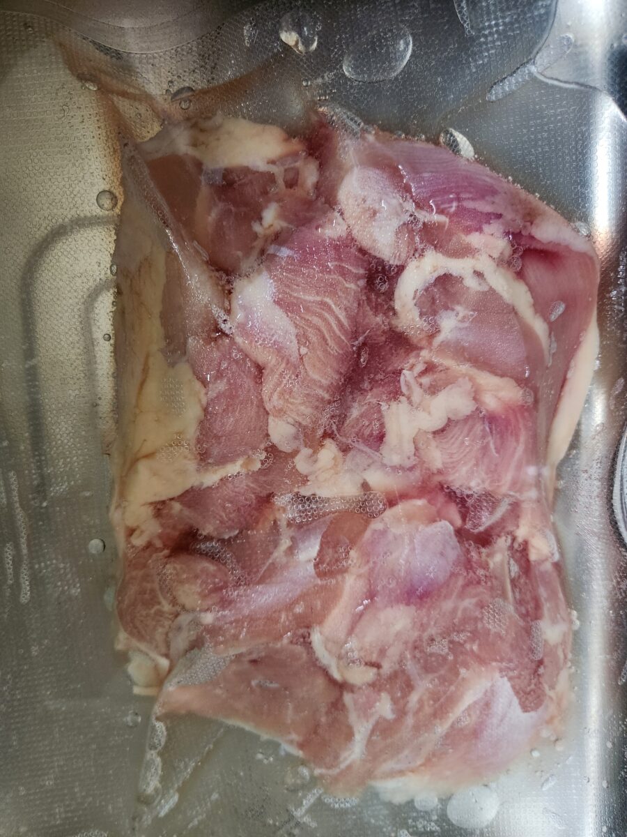 진공 포장된 상태로 물에 담겨 해동 중인 닭다리살.
