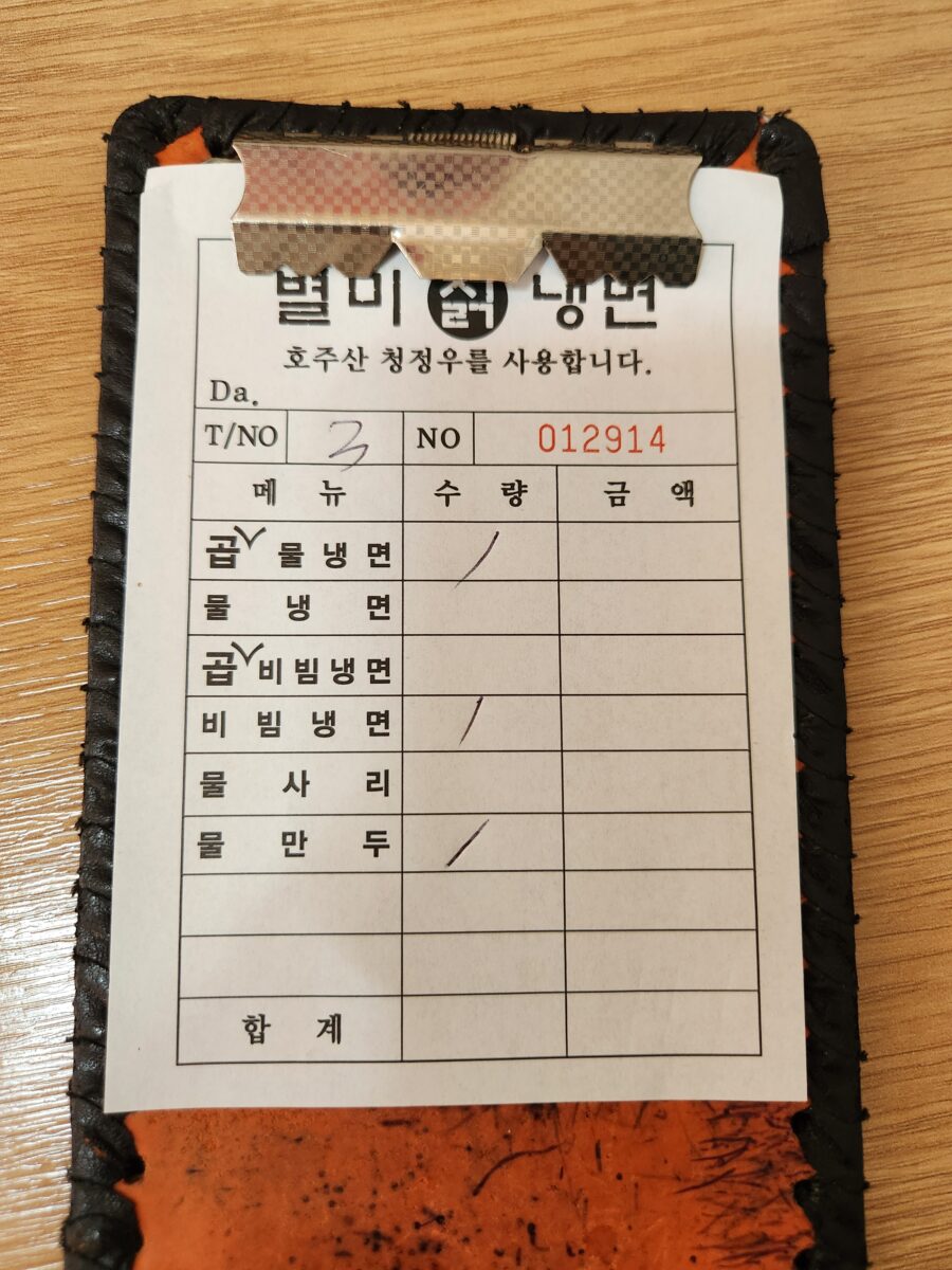 별미칡냉면 주문서가 찍힌 테이블 사진.