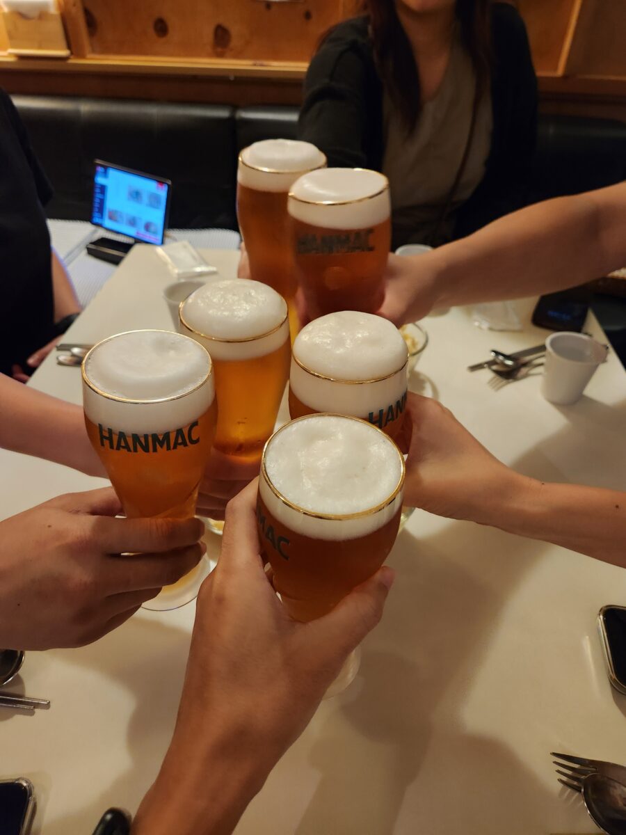 여러 명이 모여 생맥주잔을 부딪히는 모습