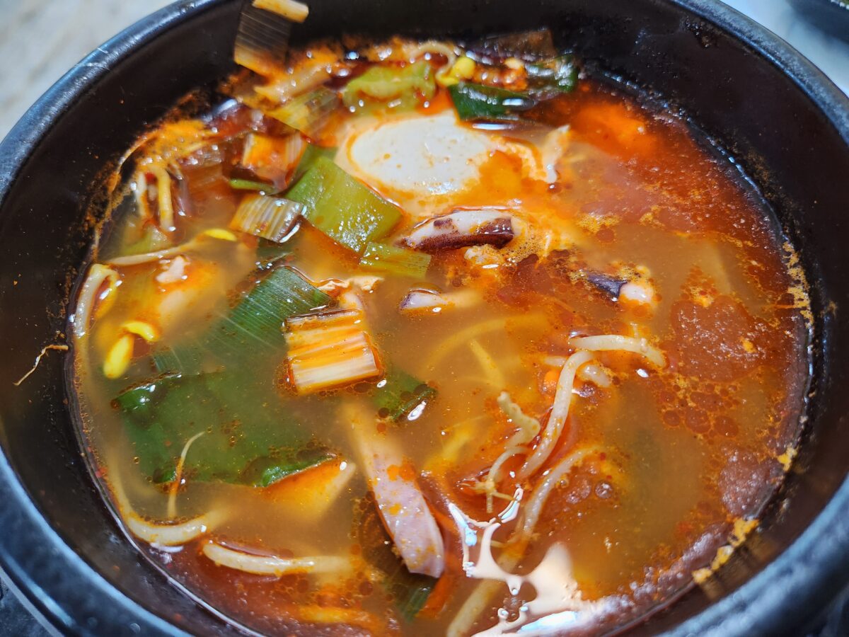 조리가 완료된 오징어해장국의 근접 촬영 모습, 콩나물과 오징어가 보임.