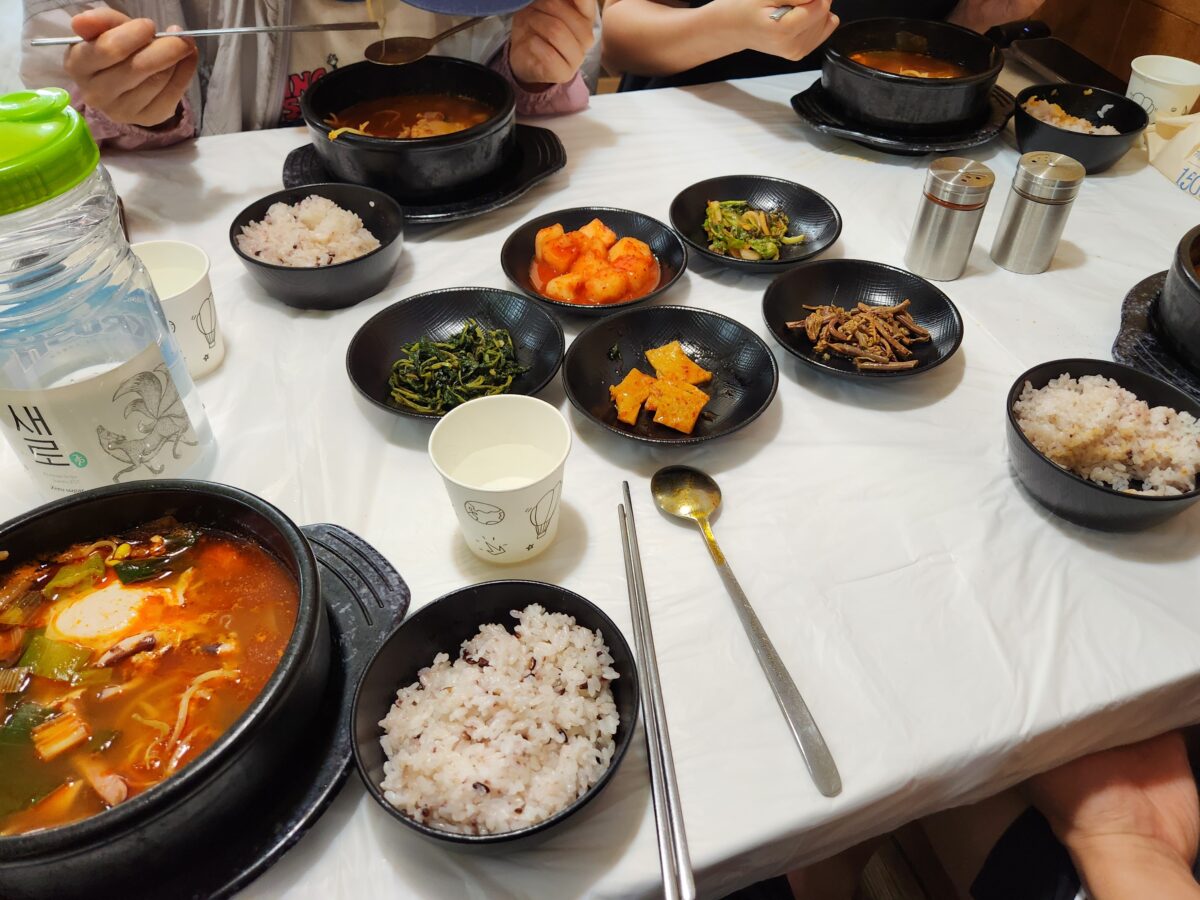 테이블 위에 차려진 오징어해장국과 여러 종류의 밑반찬들이 담긴 식탁 전체 모습.
