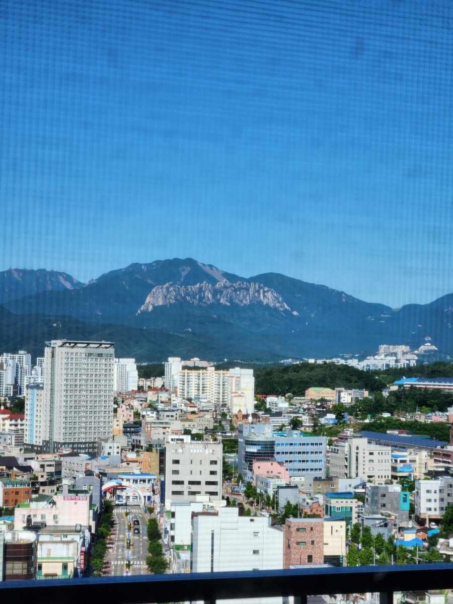 숙소 창문 밖으로 보이는 속초 시내와 울산바위가 포함된 풍경.
