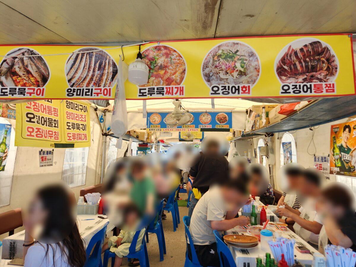 사람들로 북적이는 동명항 오징어난전 내부 모습.