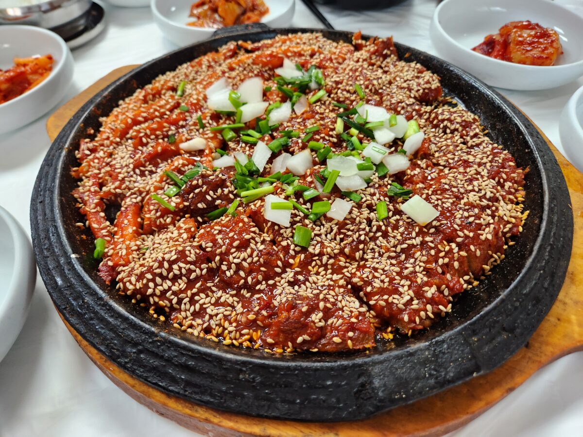 철판 위에 깨가 가득 뿌려진 황태구이와 더덕구이.