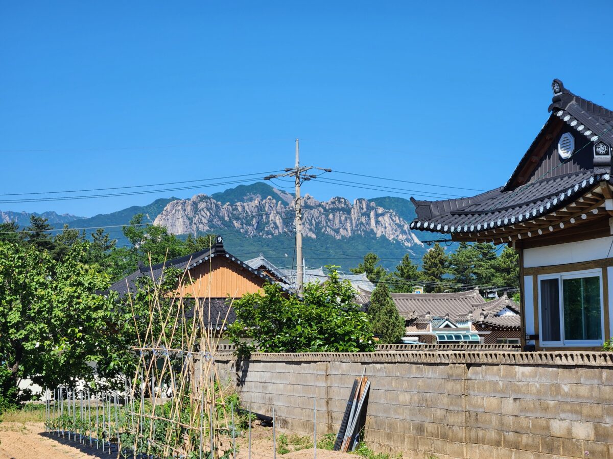 맑은 하늘 아래 보이는 울산바위와 한옥 식당 건물 외관.
