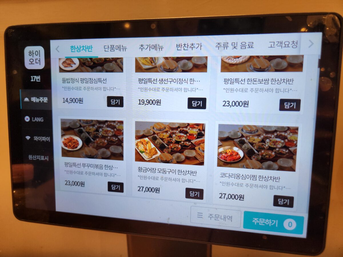 메뉴가 나열된 테이블 위 주문용 태블릿 화면.