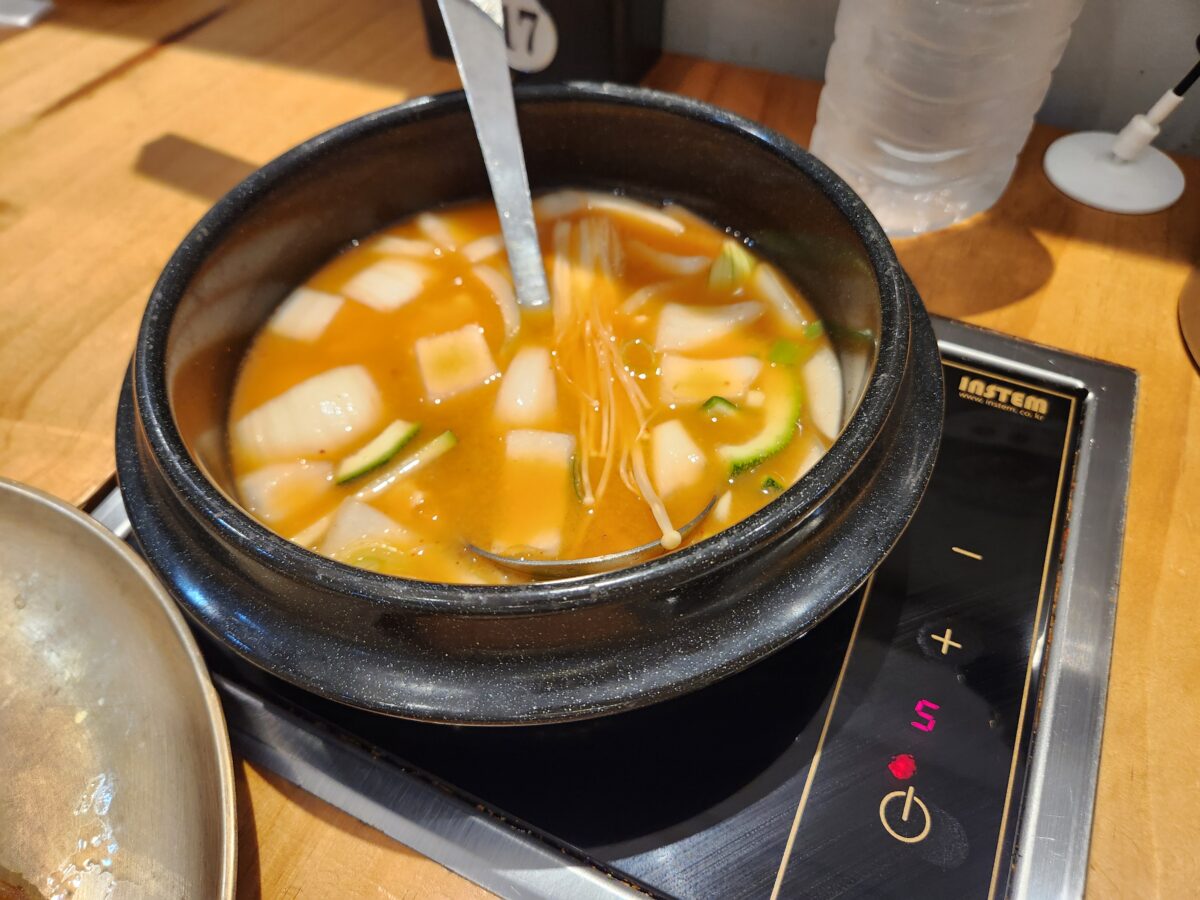 테이블에 설치된 인덕션 위에서 끓고 있는 찌개 뚝배기.
