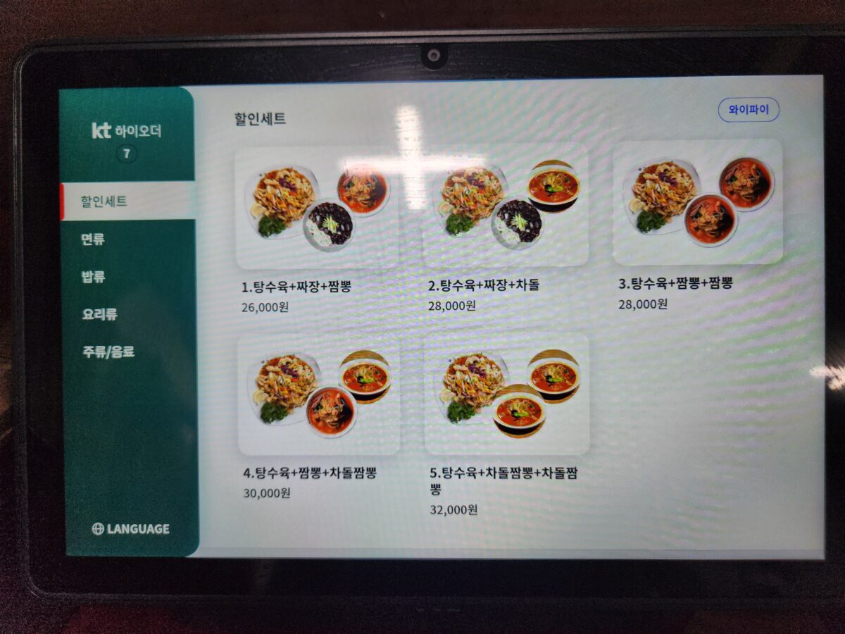 식당 테이블 위에 설치된 디지털 주문용 태블릿 화면.