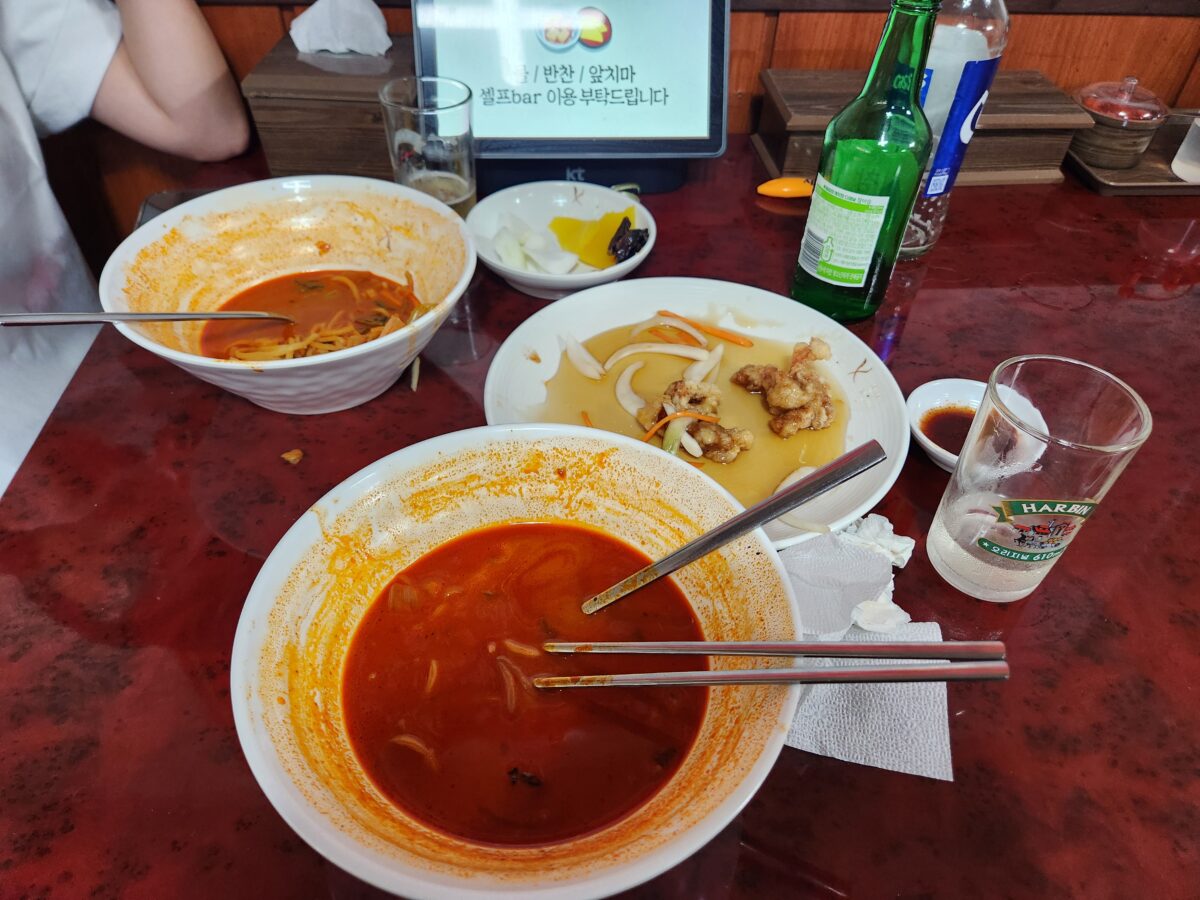 식사가 끝난 짬뽕, 탕수육, 소주와 맥주잔이 올려진 테이블 전경.
