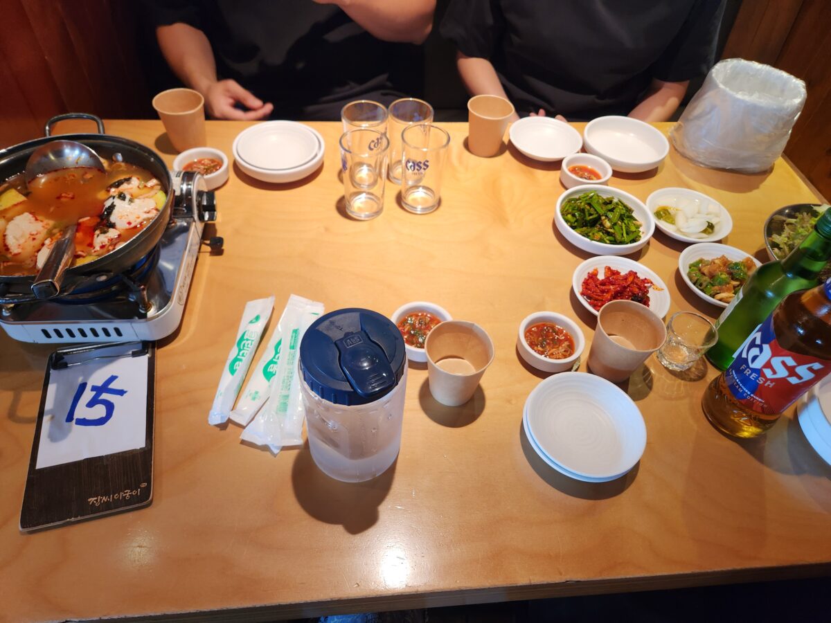 족발과 함께 제공되는 밑반찬, 소스, 순두부찌개가 차려진 테이블 전체 샷.