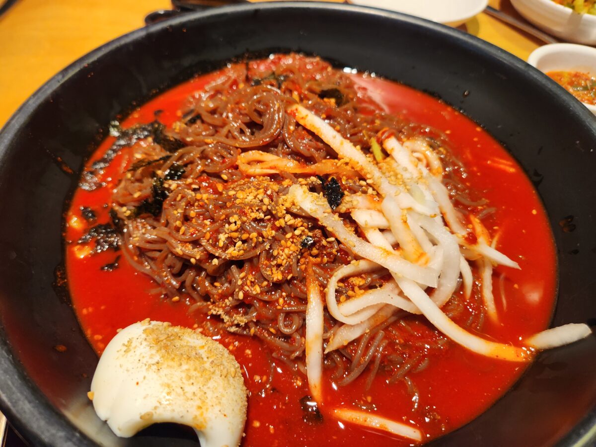 빨간 양념장이 얹어진 비빔막국수 근접 사진.