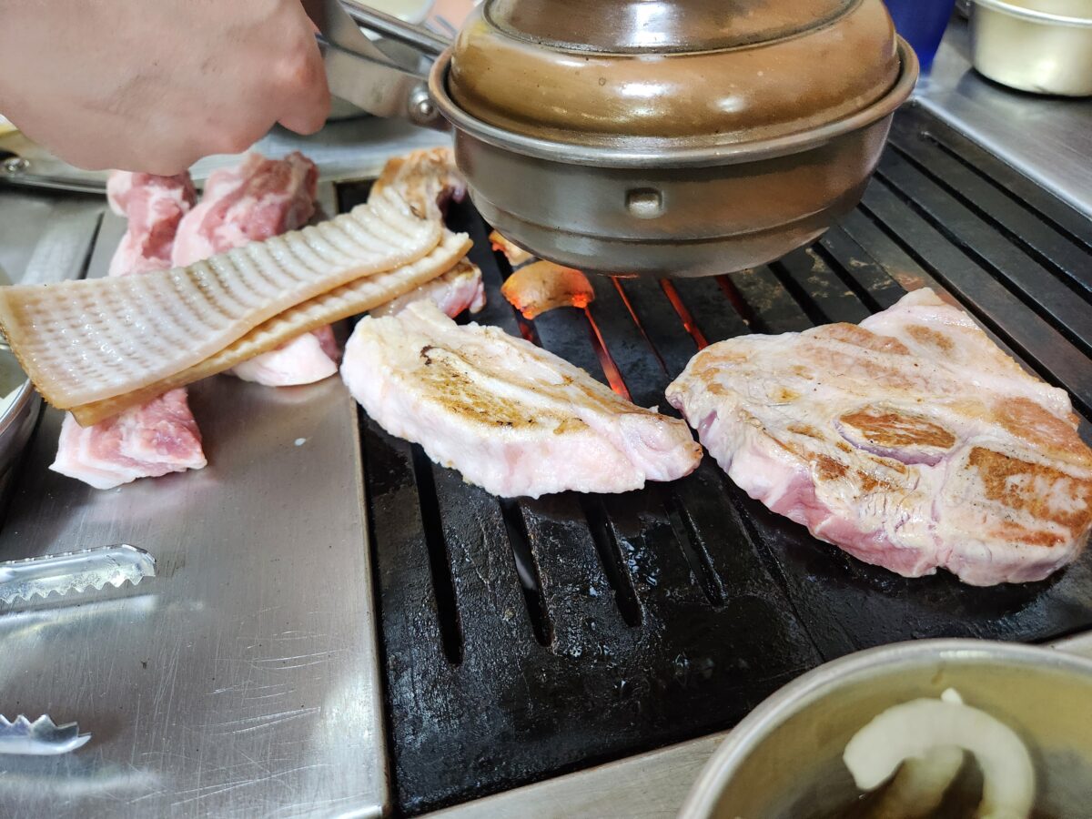 불판 위에서 구워지기 시작하는 주먹고기와 껍데기.