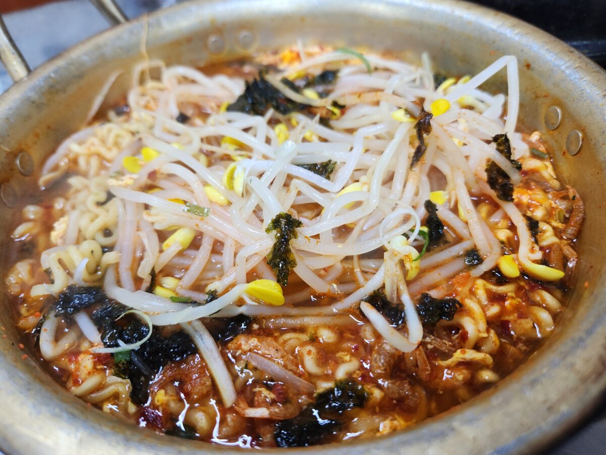 콩나물과 김가루가 올라간 냄비 속 서비스 라면.