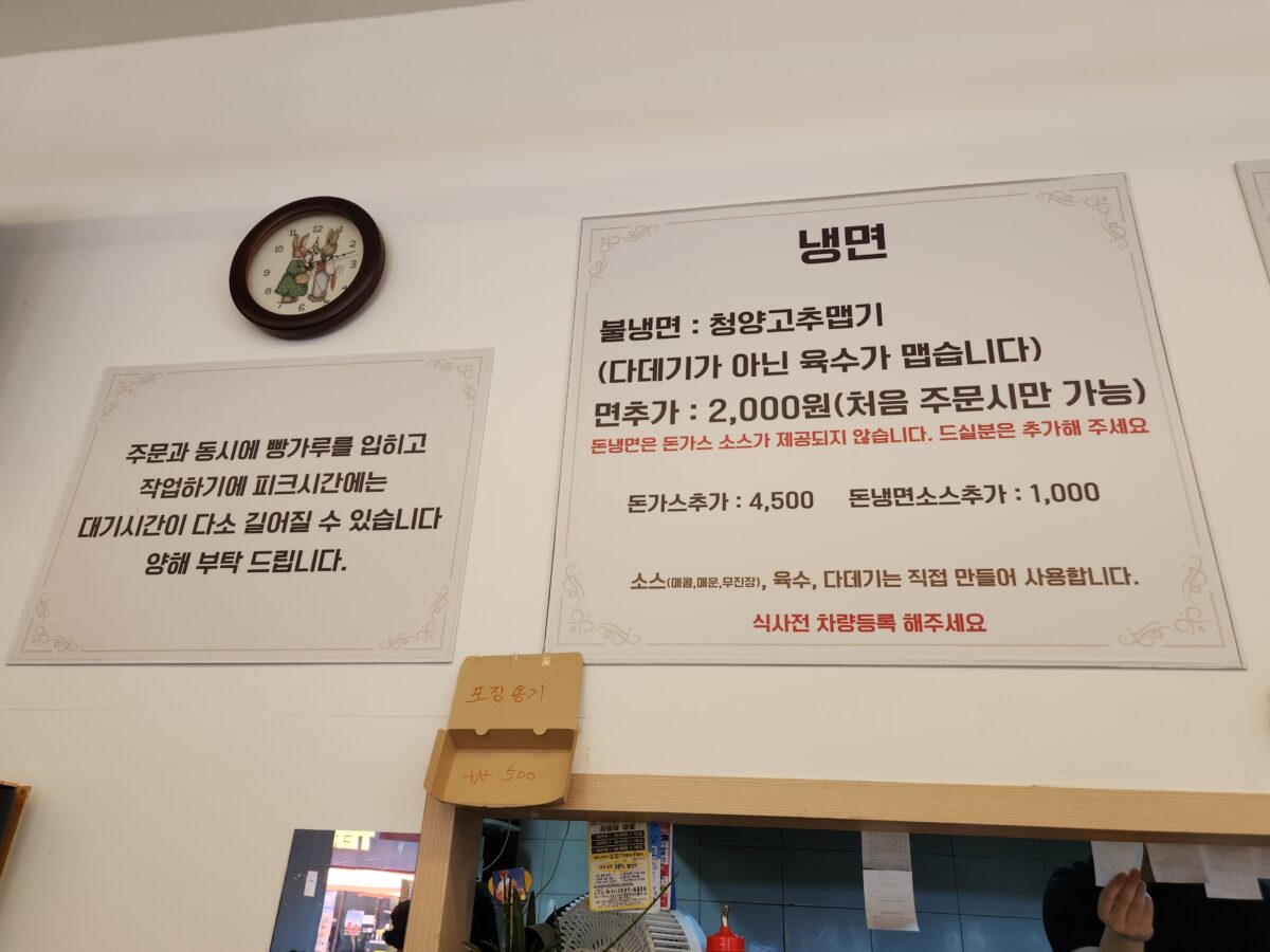 매장 벽면에 붙은 냉면과 돈까스 메뉴 설명 및 주의사항 안내판