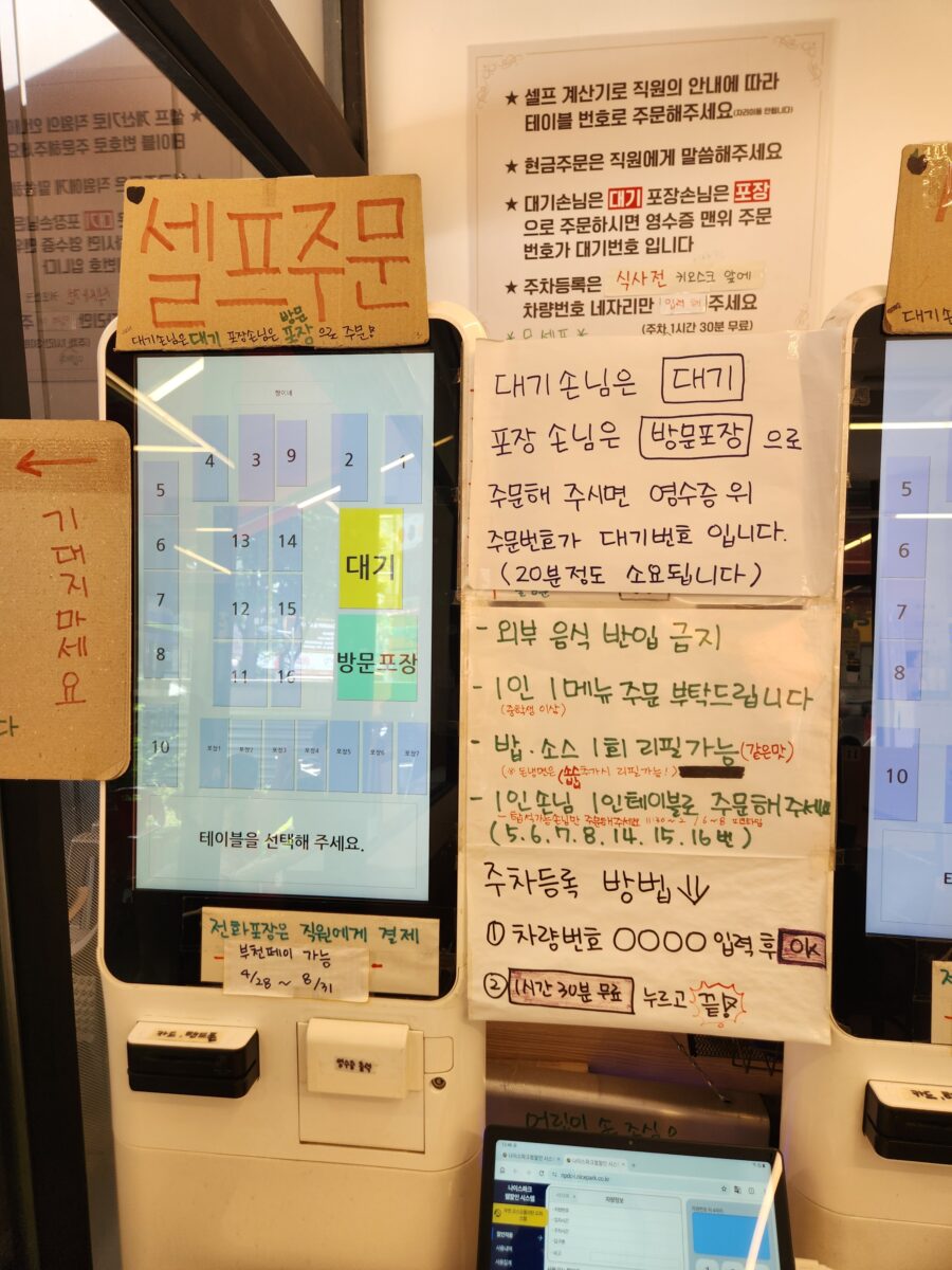 식당 입구에 설치된 키오스크와 이용 안내문