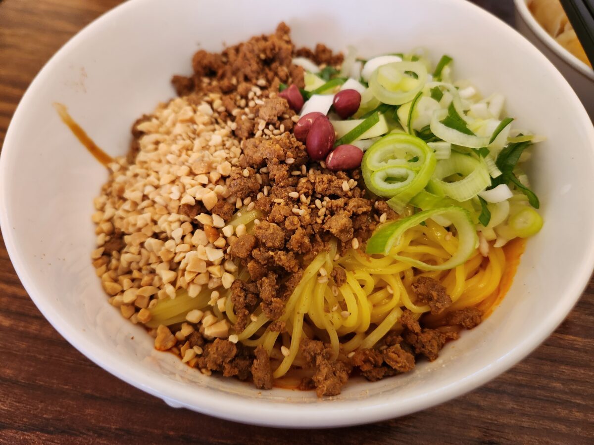 비비기 전 재료가 토핑된 비빔탄탄면.