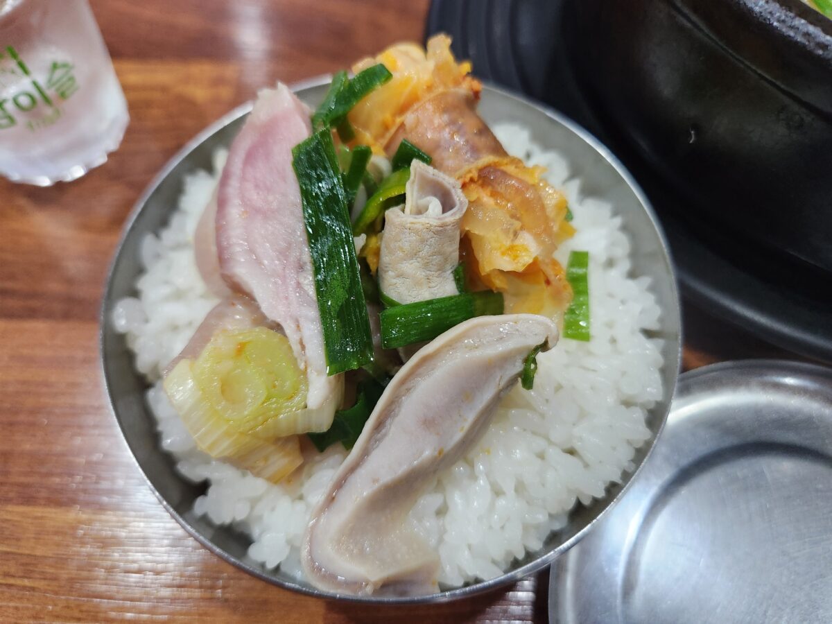 밥 위에 부속고기를 올려 먹는 모습