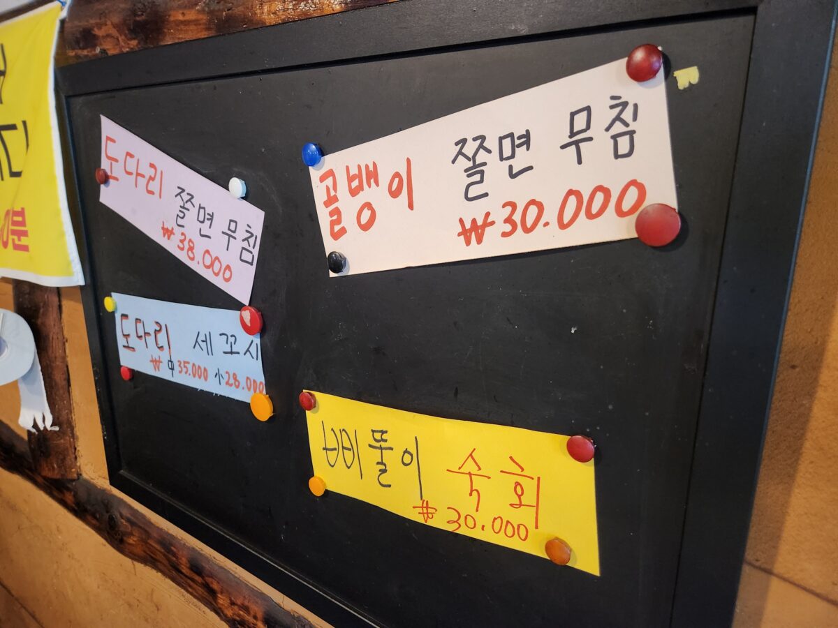 벽면에 붙어있는 메뉴판(골뱅이쫄면무침, 도다리 세꼬시 등).
